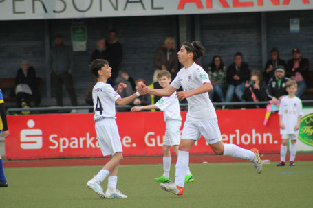 Zwei junge sümmeraner Fußballer klatschen im Spiel nach Torerfolg ab