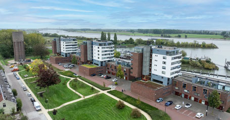 Woningontruiming Tiel – luchtfoto van appartementen aan de Waal
