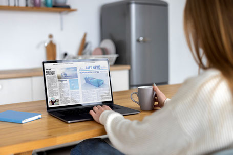 Reading news on a laptop, perfect for Spanish students and expats looking for authentic content.