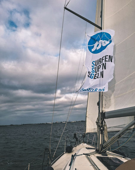 Segelschiff mit Vereinsflagge im Segel
