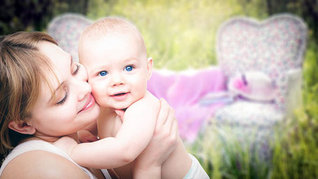 mum and baby on a relaxing cuddle in the sunny day in the garden