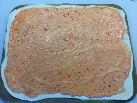 Ausgerollter Pizzateig mit Sauce auf dem Zauberstein von Pampered Chef