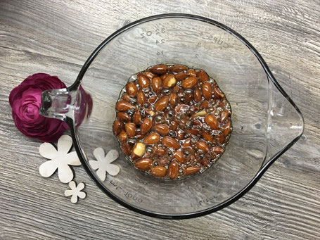 Mandeln in Glaschüssel mit flüssigem Zucker