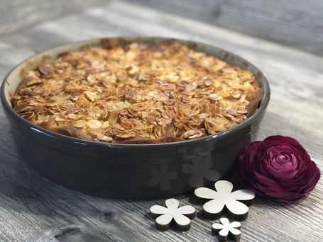 Fertig gebackener Apfelkuchen in einer grauen runden Tonbackform