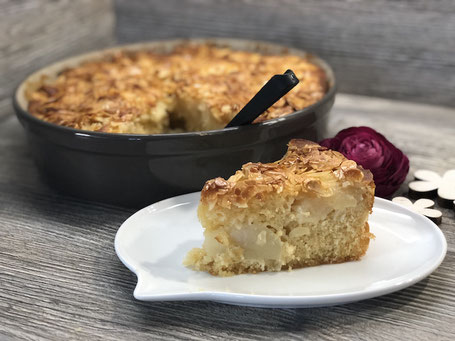 Fertig gebackener Apfelkuchen in einer grauen runden Tonbackform
