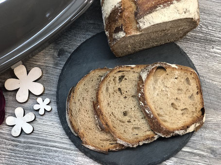 Brot auf einer Schieferplatte liegend und aufgeschnitten