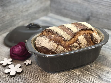 Frisch gebackenes Brot in einem Brotbacktopf liegend auf Arbeitsplatte