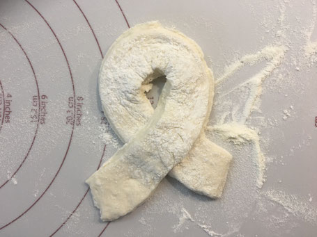 Brötchenteig auf einer Teigunterlage liegend.