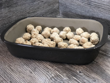 Auflaufform aus Ton in grauer Farbe mit Semmelknödel gefüllt