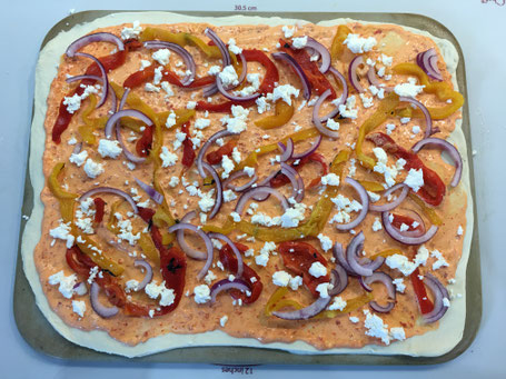 Pizza vor dem backen mit Gemüse und roter Sauce auf dem Tonbackstein von Pampered Chef