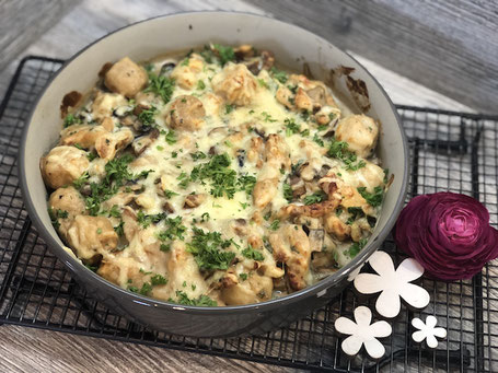 Auflaufform aus Ton in grauer Farbe mit Champignons und Schnitzel befüllt