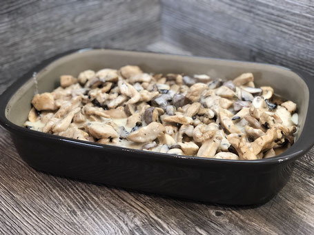 Auflaufform aus Ton in grauer Farbe mit Champignons und Schnitzel befüllt