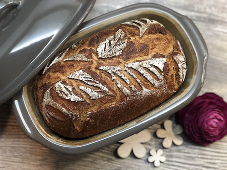 Brotteig und Brotbackform aus Ton in grau
