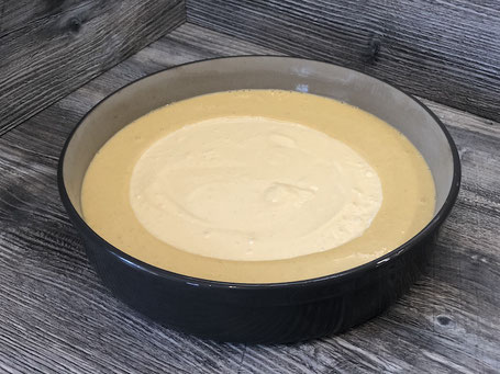 Springform aus Ton auf Arbeitsplatte mit Kuchenteig gefüllt
