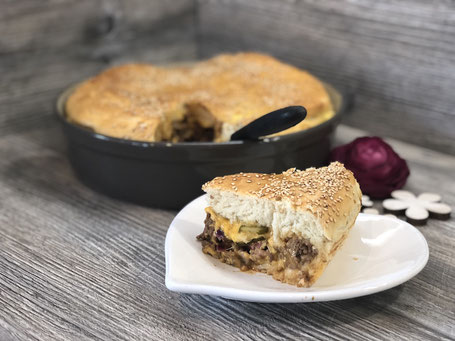 Cheeseburger-Kuchen auf Arbeitsplatte und Teller angerichtet