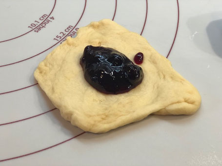 Teig aus Silikonunterlage mit Marmelade gefüllt