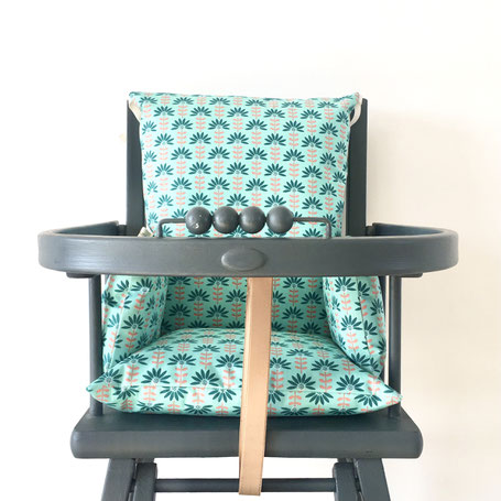 Cette image représente un coussin de chaise haute en coton enduit Vert pour chaise haute combelle