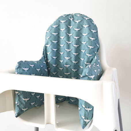 Cette image représente un coussin de chaise haute pour chaise haute Ikea bleu avec des oiseaux grues