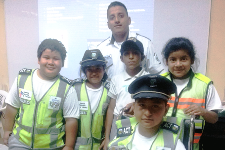 Niños de una escuela posan con su instructor municipal en materia de seguridad vial. Manta, Ecuador.