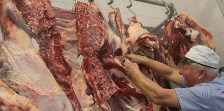 Ein Mann bearbeitet frisches Fleisch