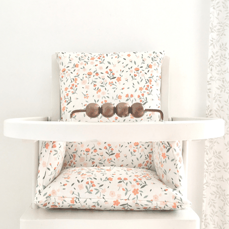 Cette image représente un coussin de chaise haute aux airs de printemps compatible avec les chaises hautes en bois de type combelle