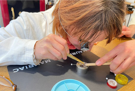 A woman works on a clockwork.