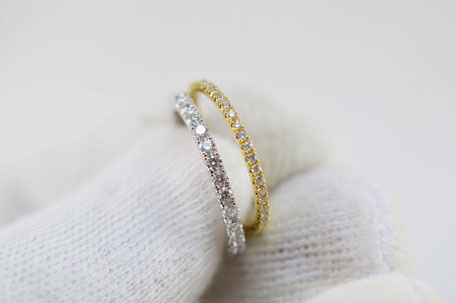 main avec un gant blanc portant une alliance de 2mm en or blanc 18 carats sertie de diamants et une alliance de 1.6mm en or jaune 18 carats sertie de diamants