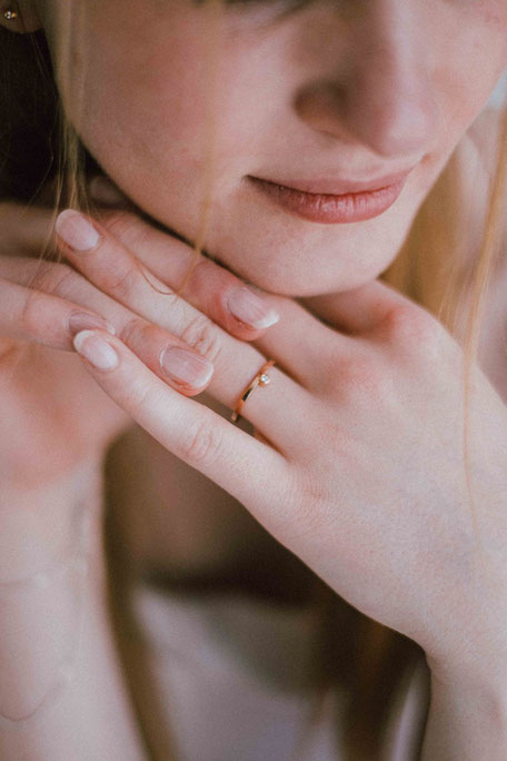 alliance Minimalist en or rose et diamant portée sur une main de femme