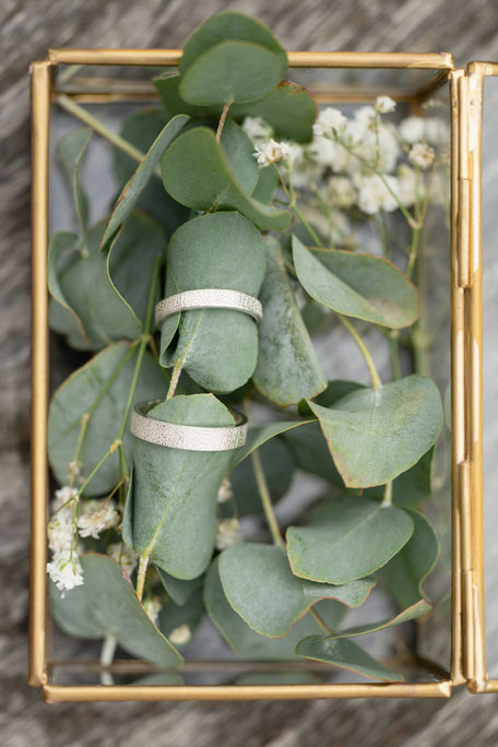 2 alliances ecoresponsables or blanc recyclé texture cuir dans écrin avec fleurs