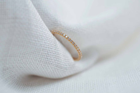 Bague en or rose 18 carats recyclé entièrement sertie de diamants tenue dans un tissus blanc