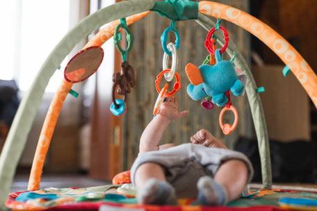 Baby spielt mit Mobiles.