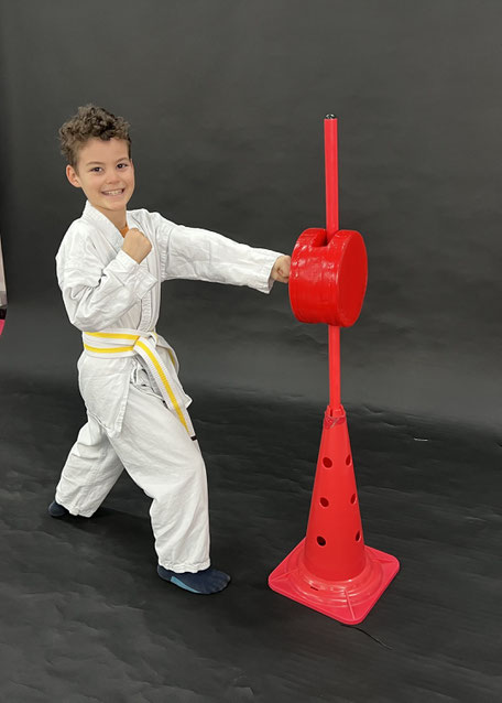 Karate Kind führt eine Karate Technik aus. Stark und Selbstbewusst. Sicherheit, Selbstschutz und Selbstverteidigung.