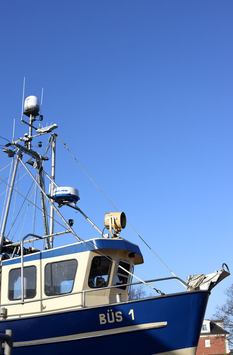 Bild von einem dunkelblauen Schiff mit der Aufschrift Büs 1 vor blauem Himmel für einen Erlebnisberciht für NAH.SH