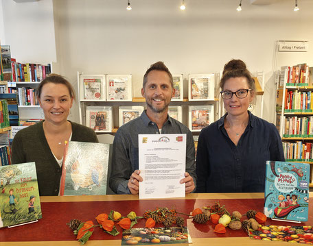Rektor Holger Laufer und Frau Maier-Hagen + Frau Oetken von der Stadtbibliothek halten stolz den neuen Vertrag in der Hand