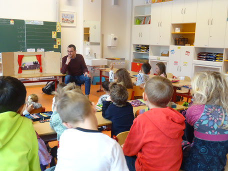 Herr Herzog liest der Klasse 1b ein spannendes Buch vor