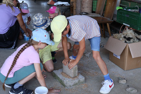 Kinder beim Mahlen von Mehl
