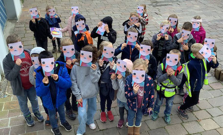 Die Kinder der Klasse 3c vor dem Engener Museum. Aus datenschutzrechtlichen Gründen halten sie das neue Prospekt der Ausstellung vor ihr Gesicht