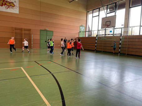 Kinder spielen Handball und freuen sich über ein Tor