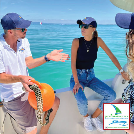 Instruktor erklärt mit Fender und Leine ein Hafenmanöver, Skipper-Briefing für Segel- und Motorbootschüler auf dem Bodensee.