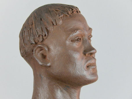 Visage de profil d'un Maori de profil, au regard profond et calme, les cheveux avec des tresses forment un bol court, le menton relevé et le nez est légèrement en trompette.