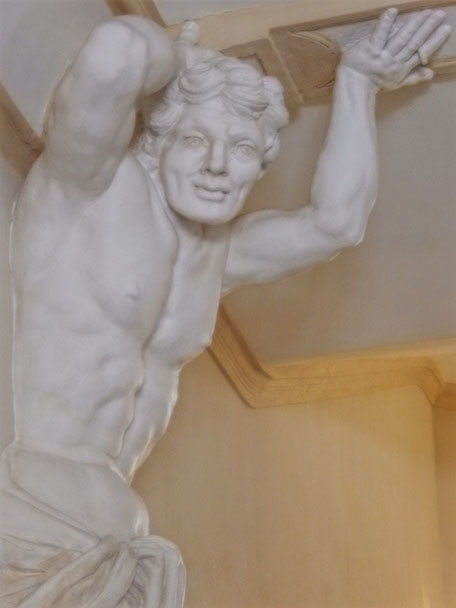 Un buste de géant, torse nu, en stuc blanc patiné soutien le plafond de l'immense hall d'entrée