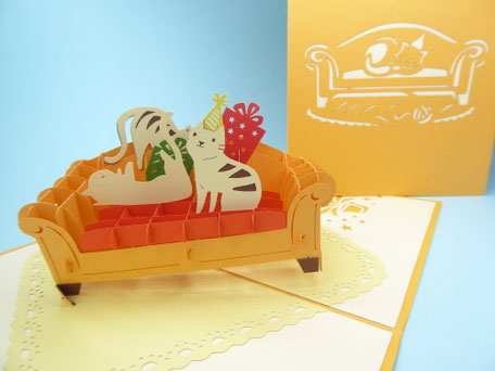 Carte pop-up anniversaire avec chats et cadeaux sur un canapé