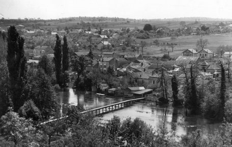 Carte postale réalisée après 1930 puisque le lavoir des Seguins, au bout de la passerelle, est couvert.
