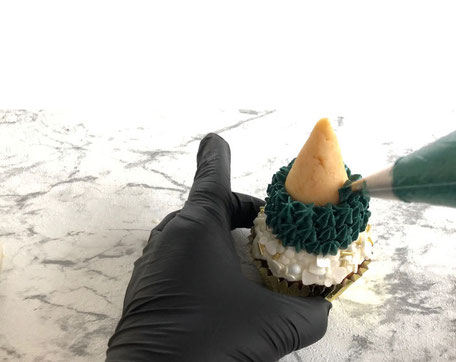 Die Tonka - Sahne - Creme anschließend auf die gekühlten Cakepop - Kegeln aufspritzen, sodass man eine schöne Tannenbaum-Spitze erkennen kann