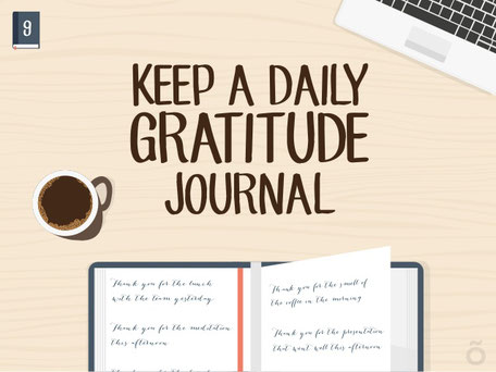 A cup of coffee, gratitude journal and a laptop on a table