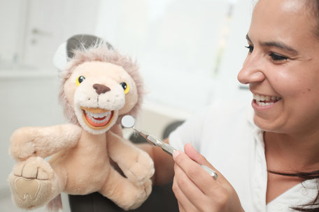 spielerische Untersuchung der Kinder beim Zahnarzt mit Kuscheltier Leo Löwe