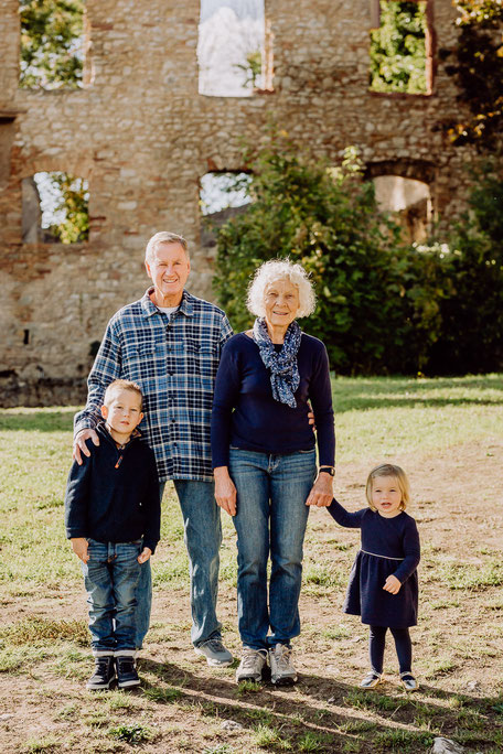 Oma und Opa mit Enkeln an der Hand lächeln