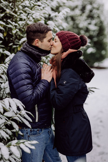 Paar küsst sich in schneebedeckter Landschaft