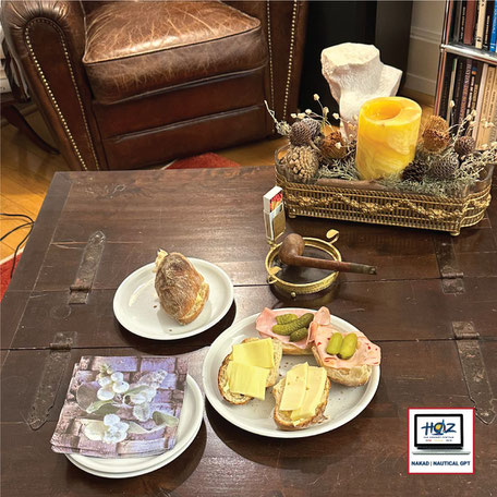 Gemütlicher Raum mit gedecktem Tisch, belegten Brötchen, Kerze und Pfeife – Lernpause in vertrauter Umgebung, symbolisch für den persönlichen und menschlichen Charakter der HOZ-Lernkultur.