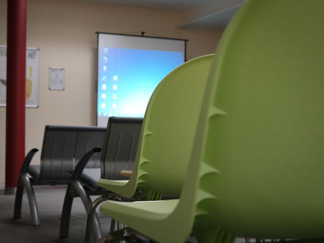 Stühle und Leinwand in einem Seminarraum